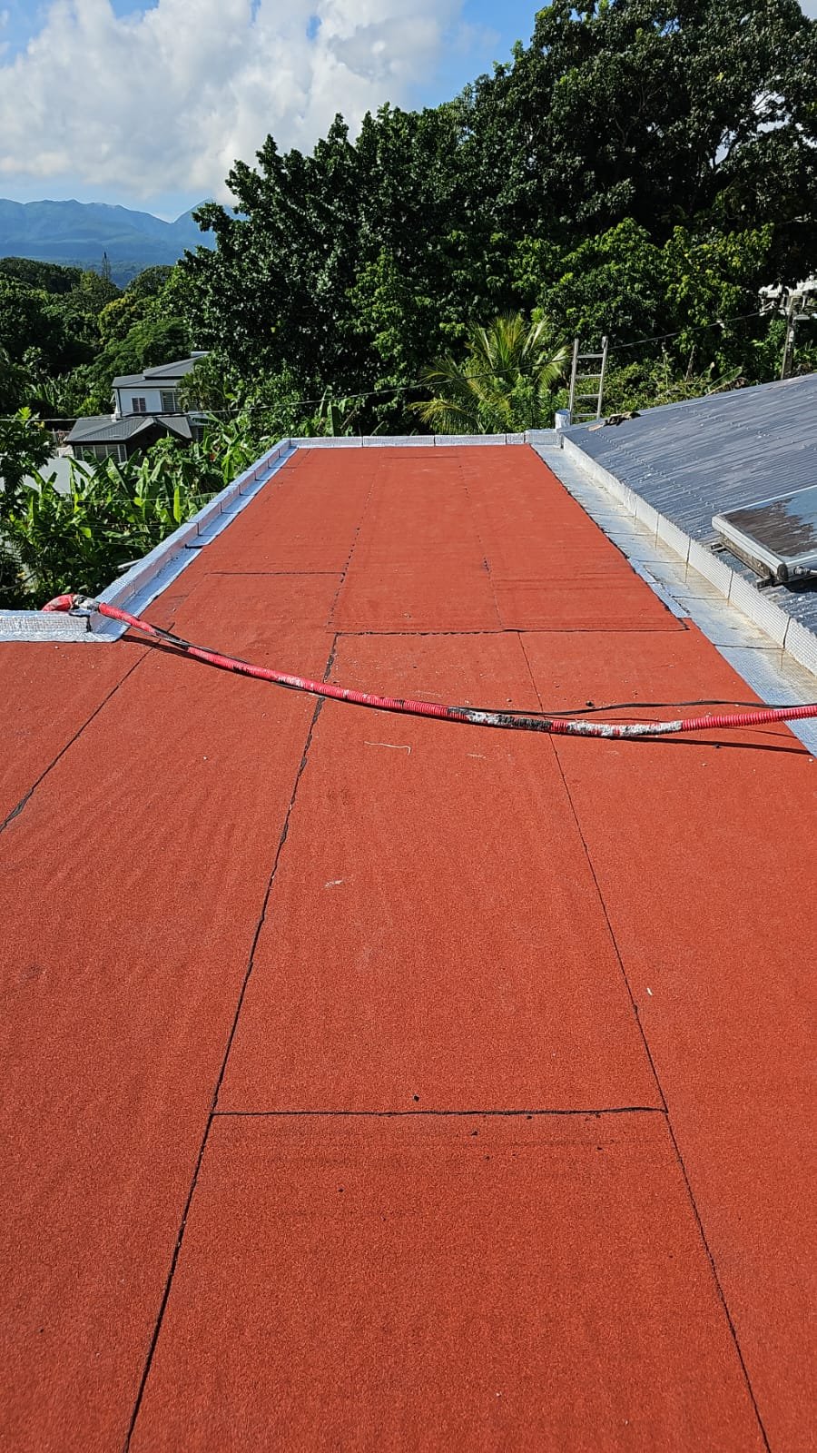 Membrane d'étanchéité rouge sur grande surface de toiture